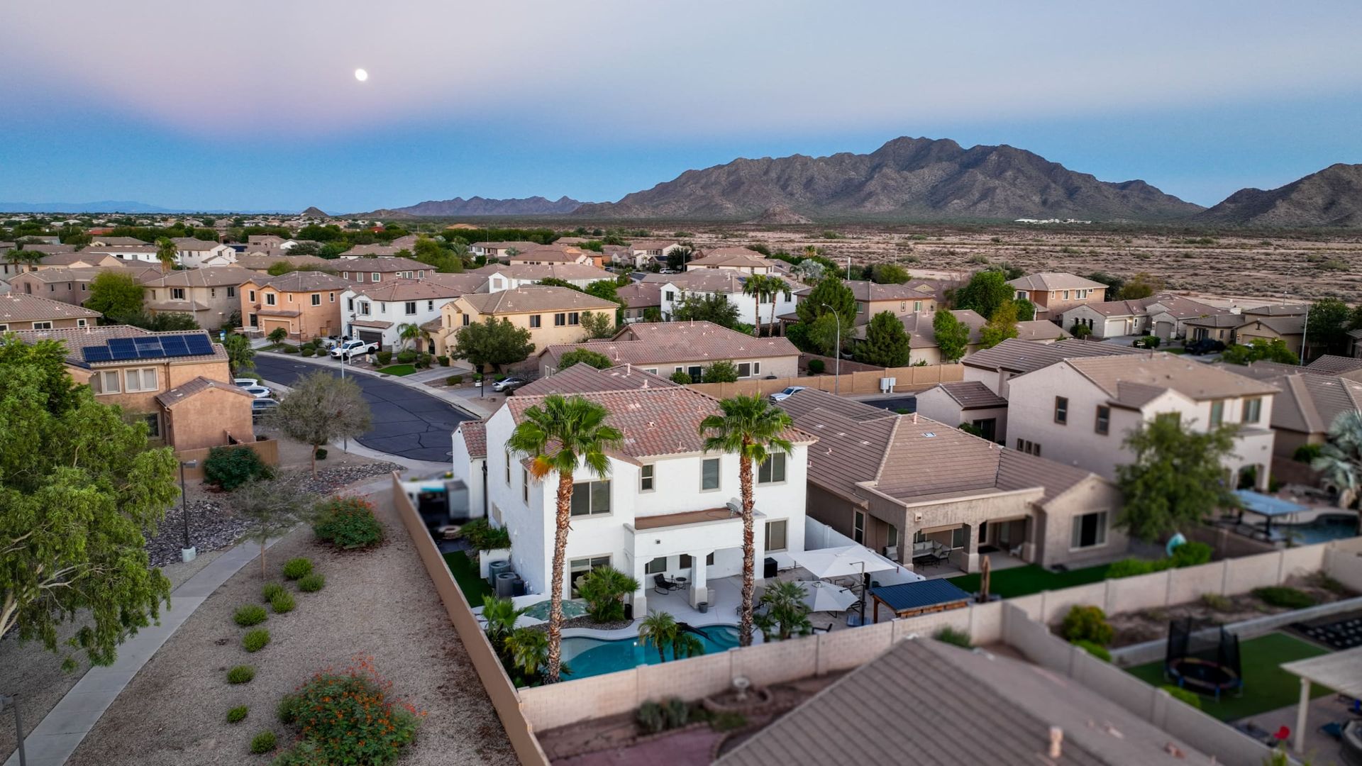 Two-story home at dusk with mountains behind